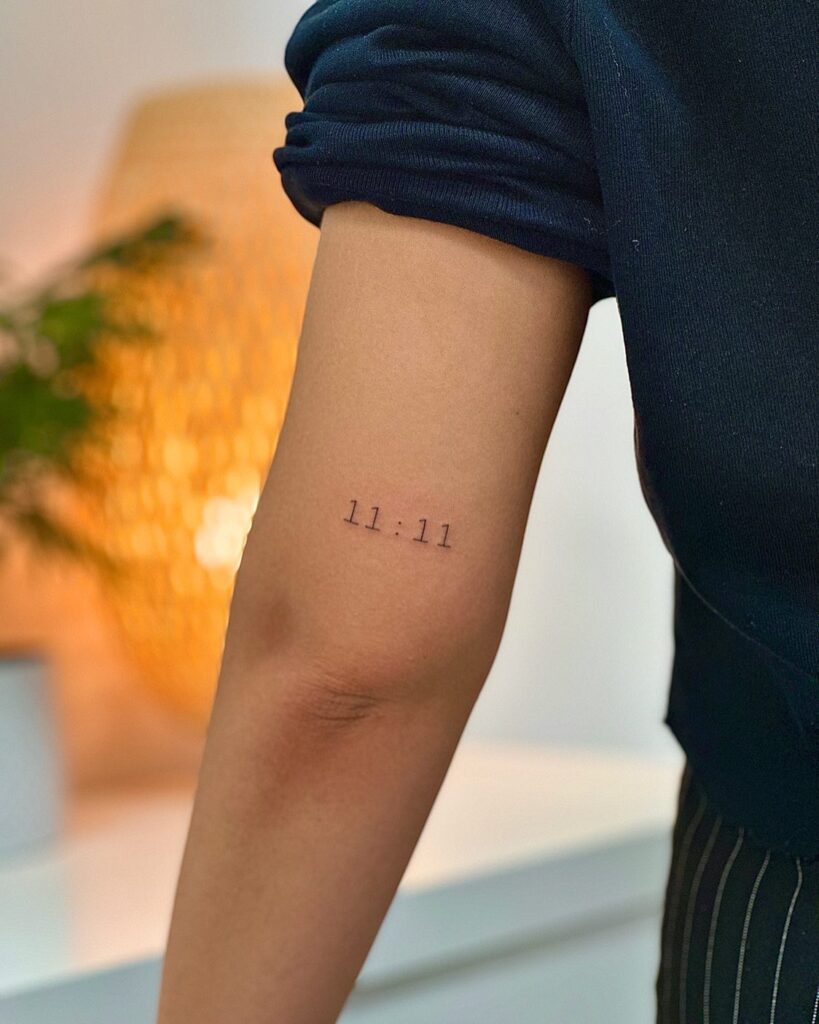 '11:11' Text Tattoo on the Back of the Above the Elbow: Timeless Synchronicity