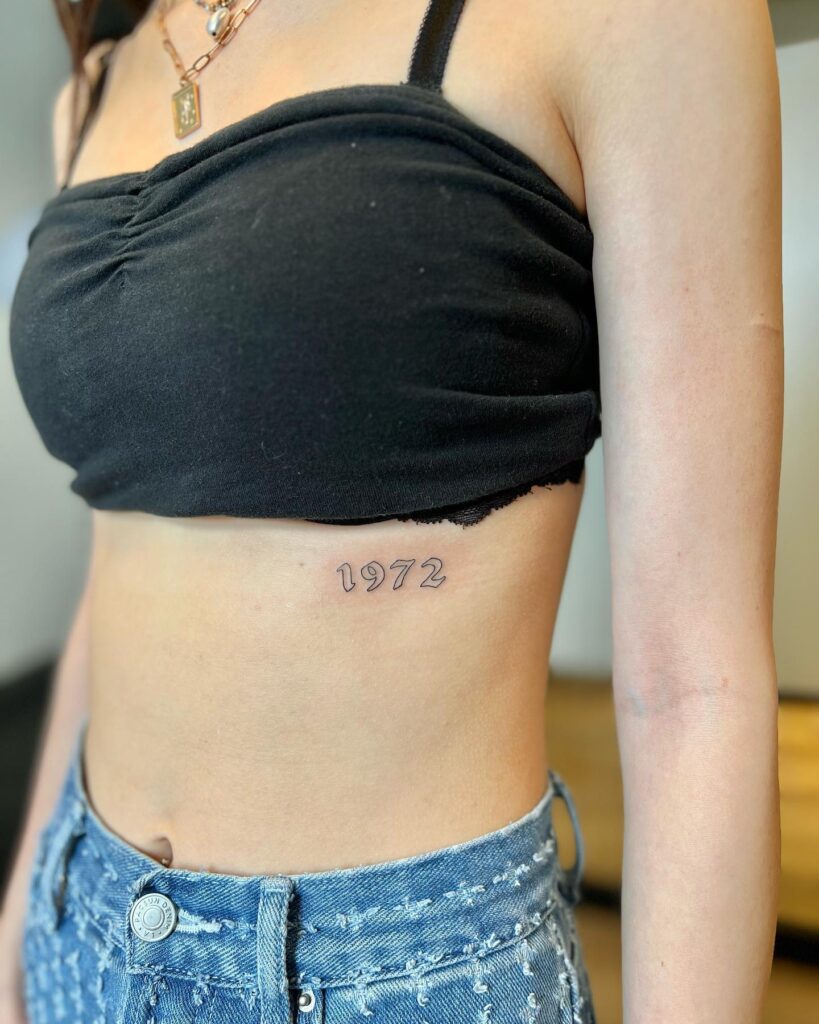 1972 gothic font old english script tattoo on the rib, outline numbers in elegant form: vintage echo