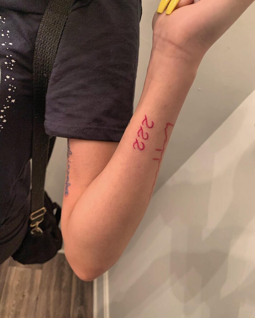 222 Red Color Text Tattoo on the Side of the Forearm, a Bold Declaration: Vivid Expression 