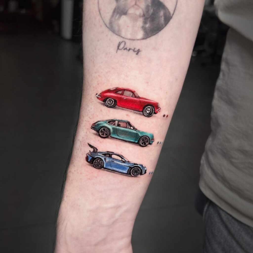 Detailed 356 Coupe, 911 Carrera, and 1964 911 GT3 RS Tattoo with Red, Green, and Blue Colors on Inner Forearm