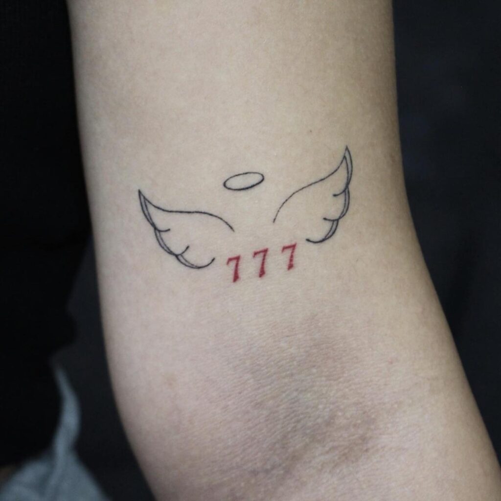 777 number nestled between wings above the elbow, minimalistic in red for a stylish touch wings of luck 