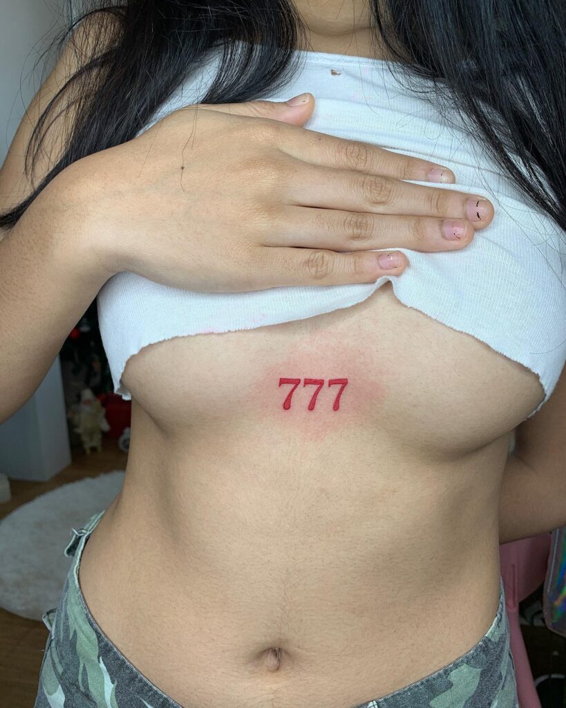 777 Tattoo in Red Color at the Middle of the Breast: Red Radiance 