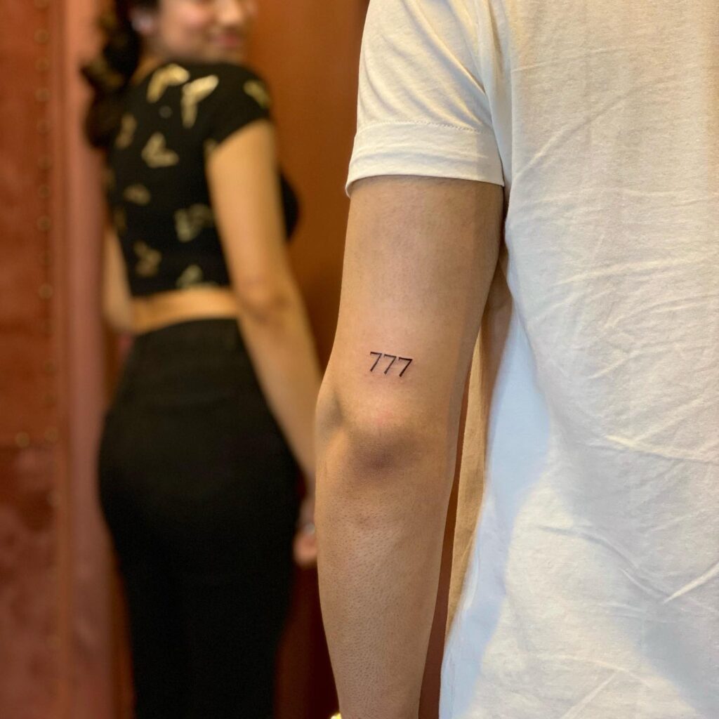 777 Tattoo on the Back of the Elbow for a Delicate Look: Graceful Curve 