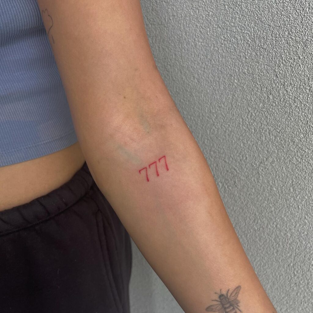 '777' Red Fineline Number Tattoo Below the Elbow: Lucky Sevens