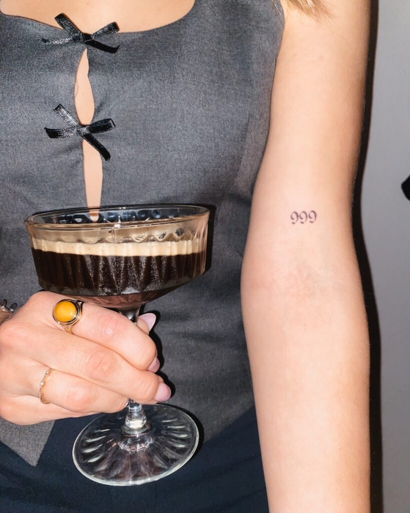 '999' Angel Number Tattoo on the Above the Elbow: Triple Harmony