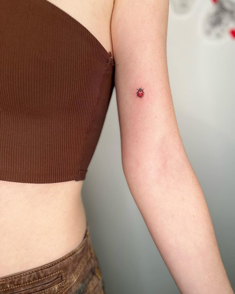 A hidden delight small inner ladybug bicep tattoo for females