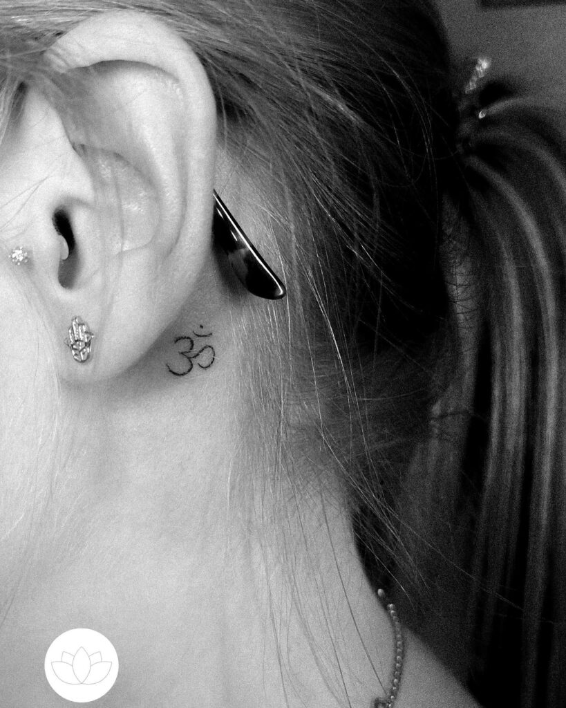 A Minimalistic Spiritual Touch: Tiny Om Symbol Behind the Ear