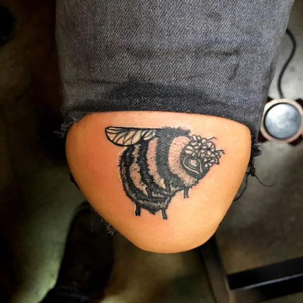 Above knee bee tattoo