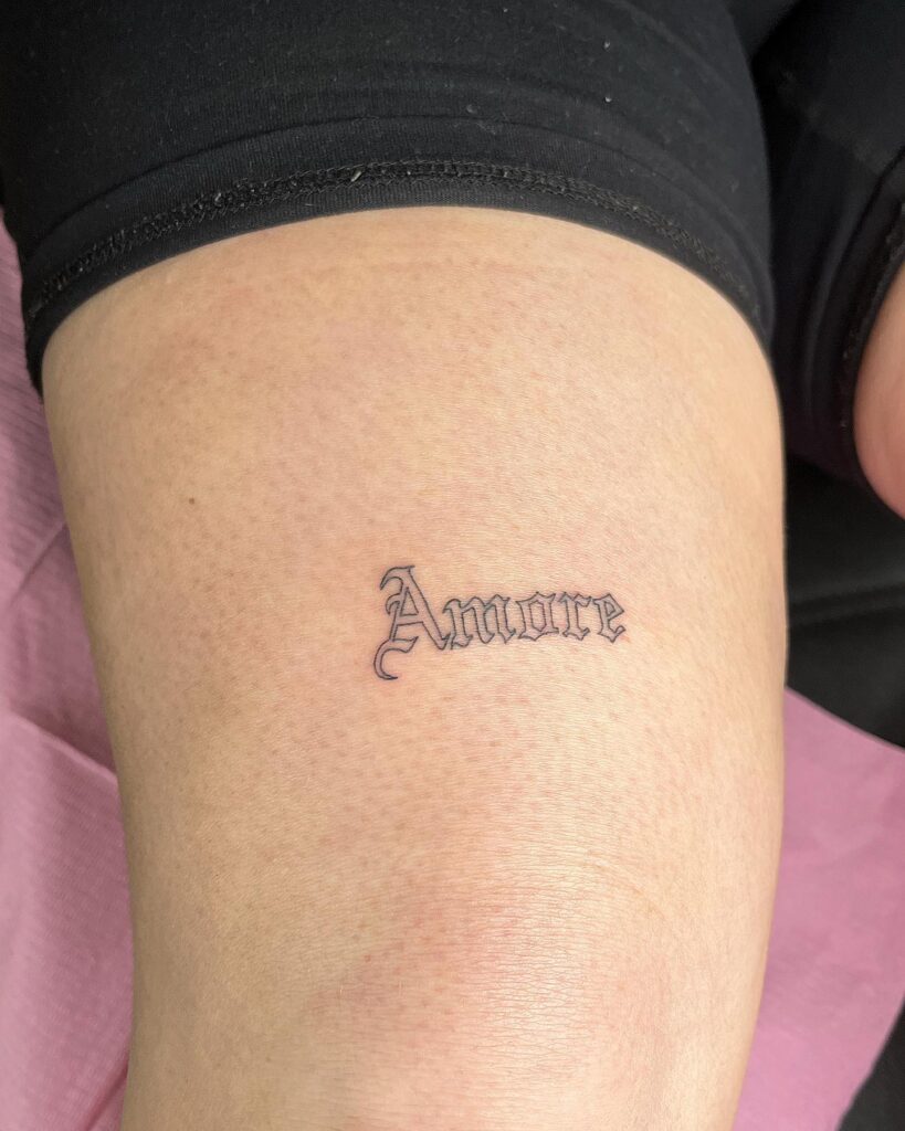 Amore always a romantic amore text tattoo above the knee