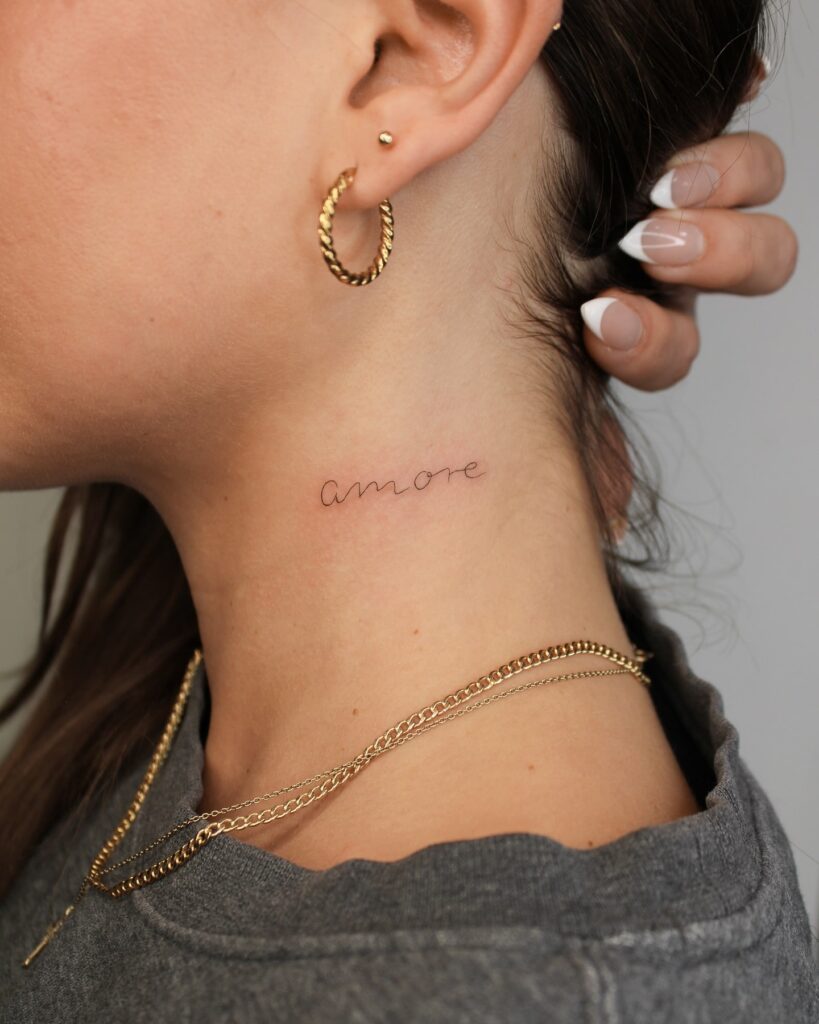 Amore tattoo in elegant cursive on the neck for a romantic aesthetic