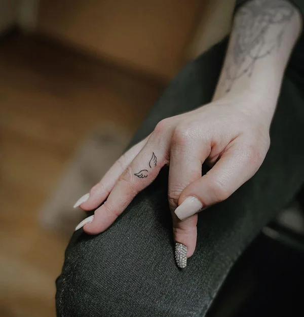 Angel wings finger tattoo