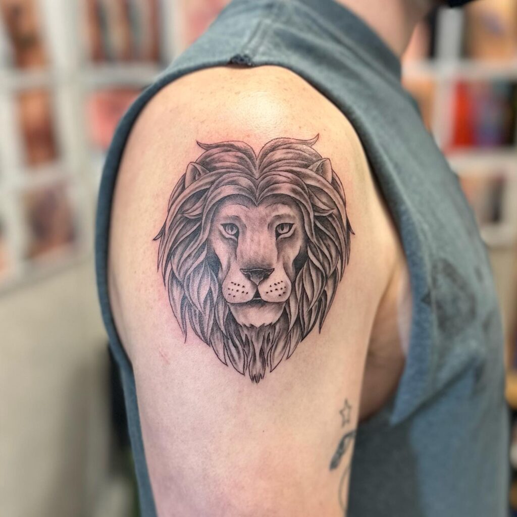 Arm and shoulder black and grey lion head tattoo: monochrome elegance