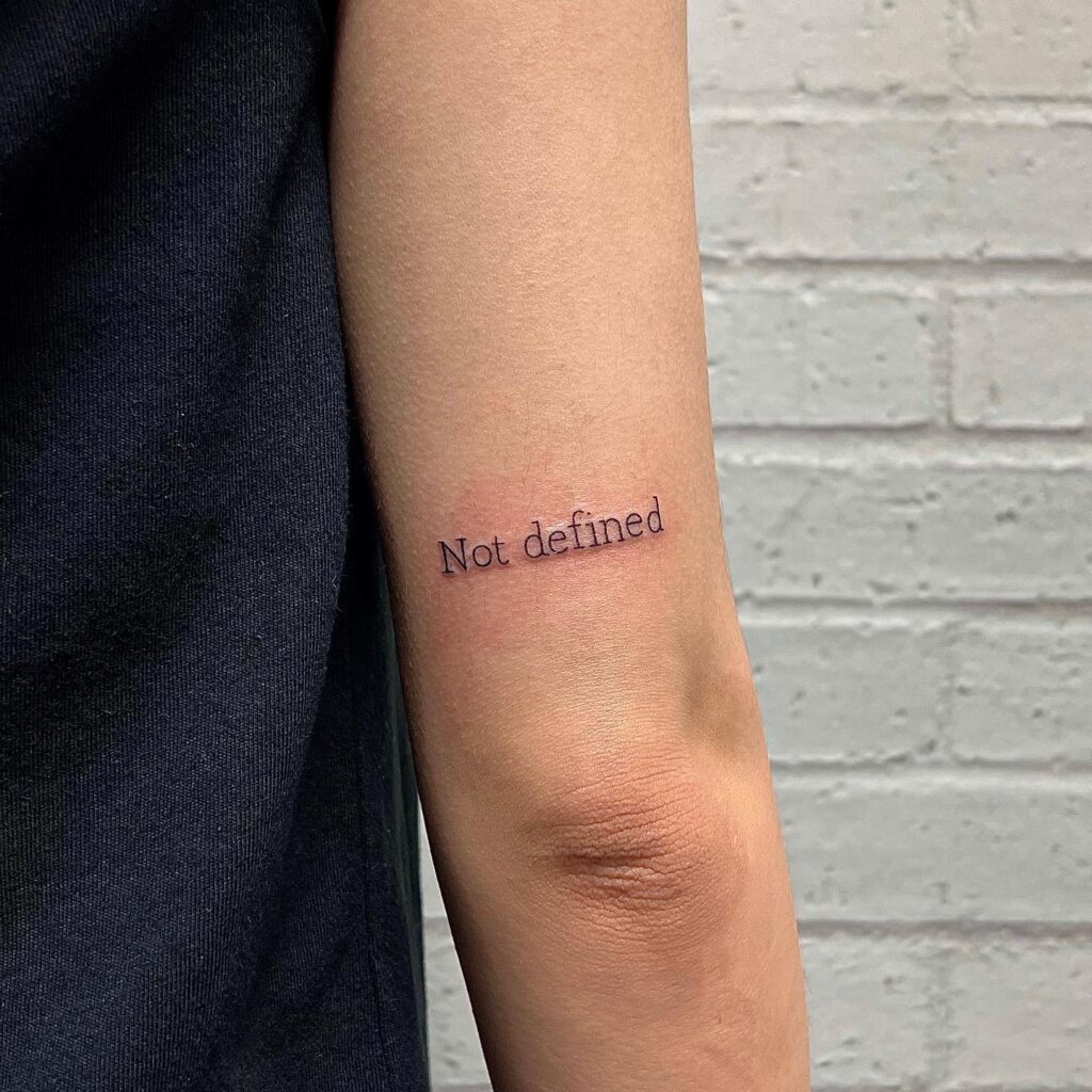 Arm articulation 'not defined' text tattoo on the back of the arm