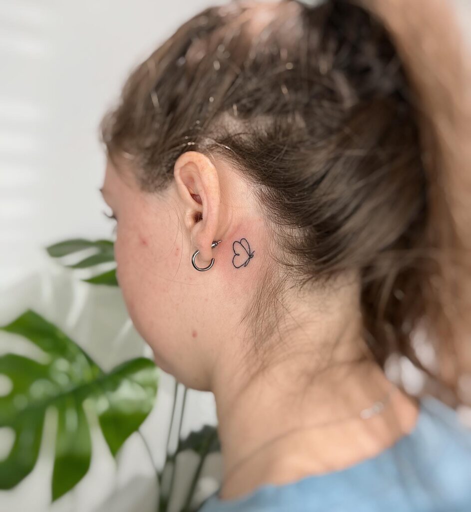 Baby butterfly outline tattoo graceful accent behind the ear for women