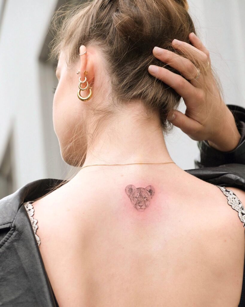 Baby lion head tattoo on the back of the neck: cute cub charm