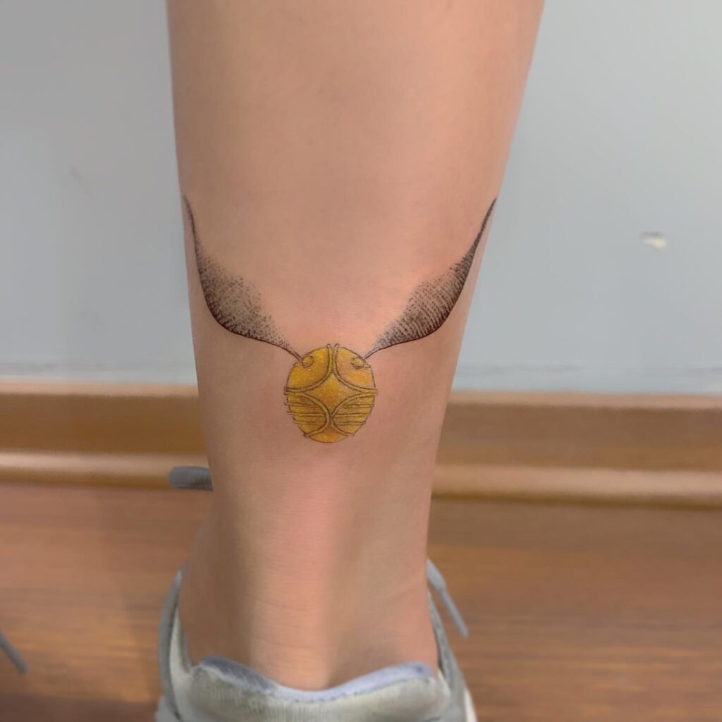 Back of lower leg golden snitch tattoo for females subtle enchantment