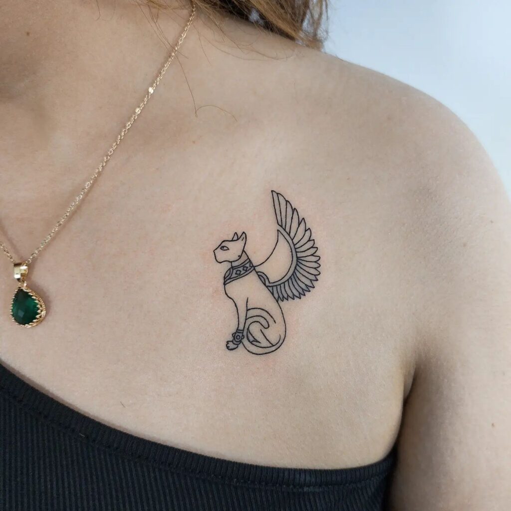 Bastet tattoo on the collarbone, side view minimal outline of the egyptian goddess