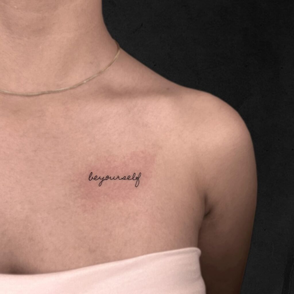 'Be yourself' meaningful word tattoo on the collarbone with no spaces, crafted in handwriting font authentic expression
