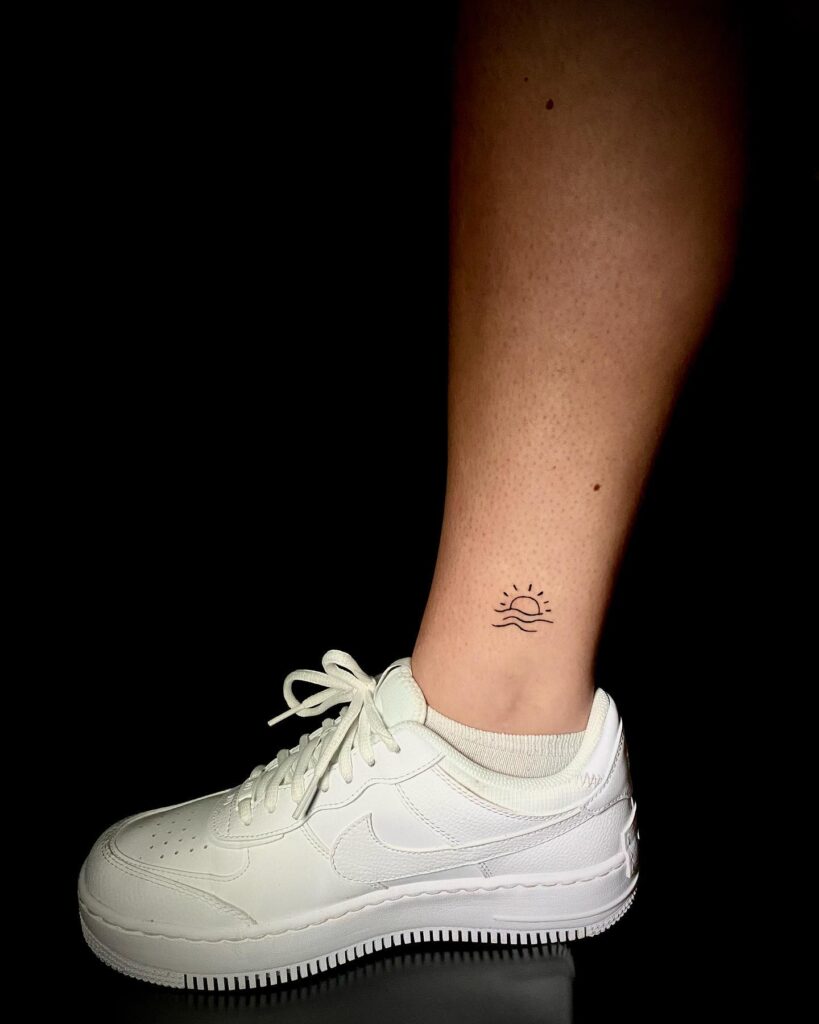 Beach wave and sun tattoo on inner ankle nature-inspired and serene tattoo design