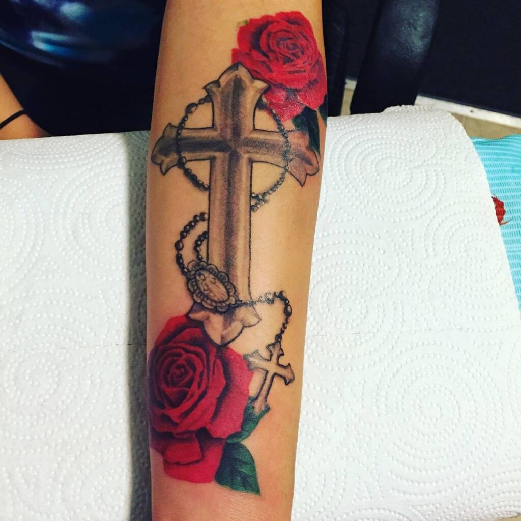 Beautiful Tattoo on Arm: Faith Expressed with Cross and Roses
