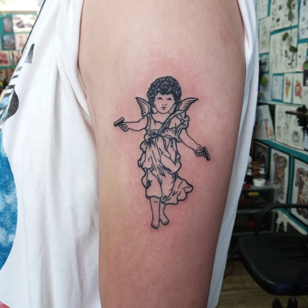 Beautiful upper arm angel with gun tattoo a heavenly guardian for men