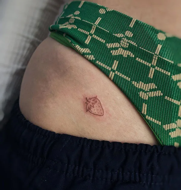 Bikini line strawberry tattoo