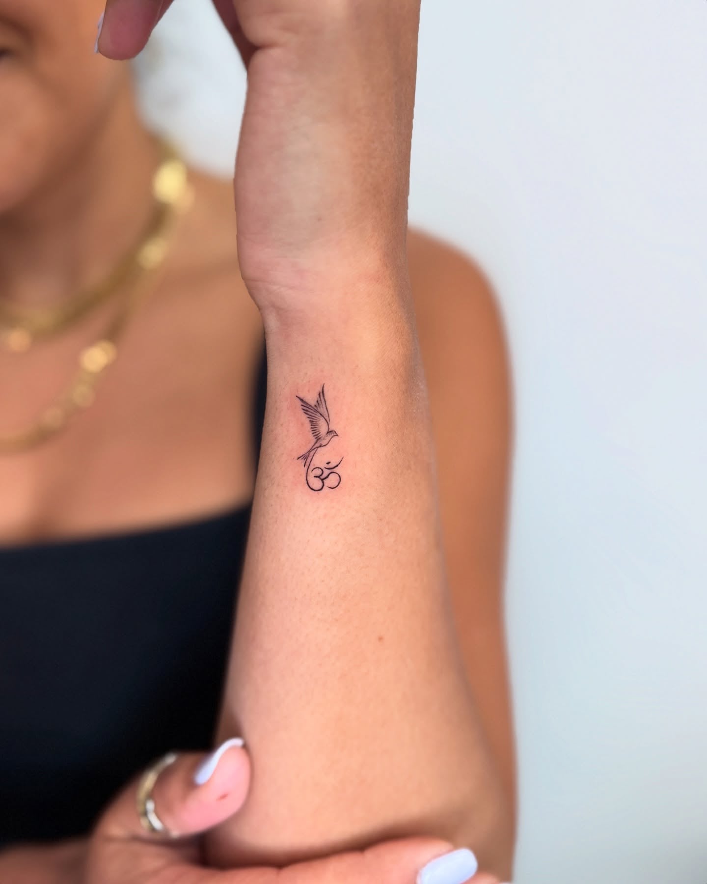 Bird and Om Symbol Wrist Tattoo Spiritual and Meaningful Minimalist Tattoo Idea