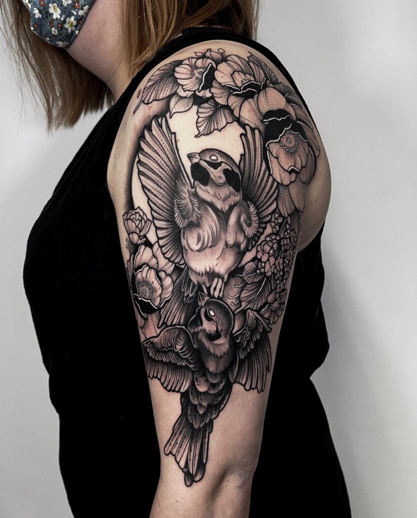 Birds and blooms bold arm and shoulder tattoo: graceful flight amidst blooming life