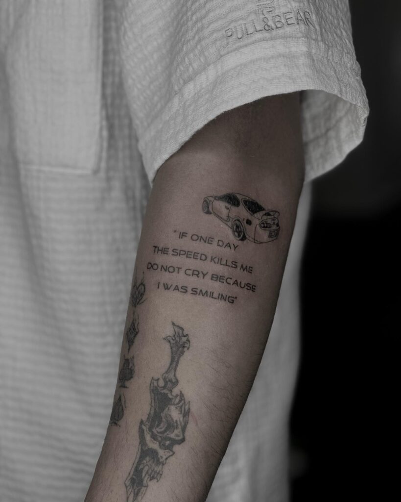 Black and Gray Toyota Supra Tattoo with Red Accents & Paul Walker Quote on Outer Forearm – Car Tattoo Ideas