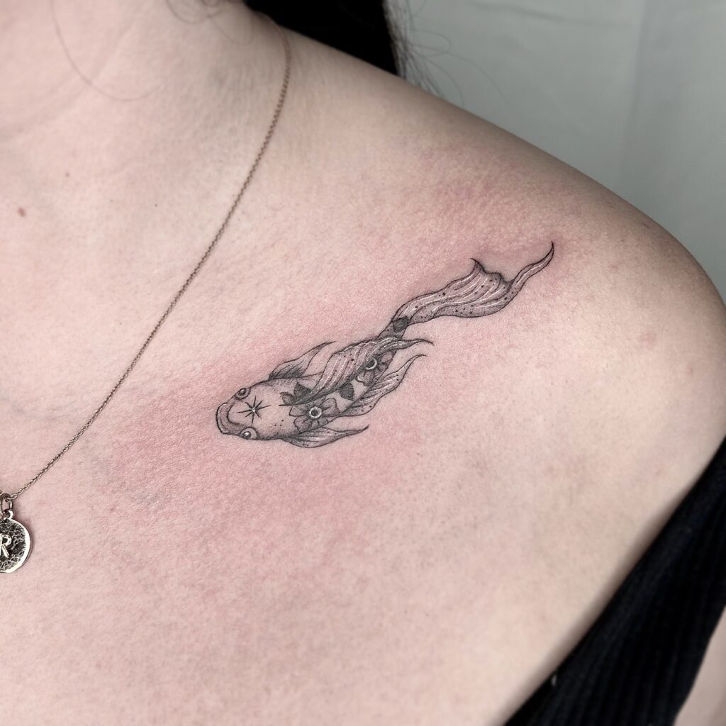 Black and grey koi tattoo on the collarbone: lil' fish details