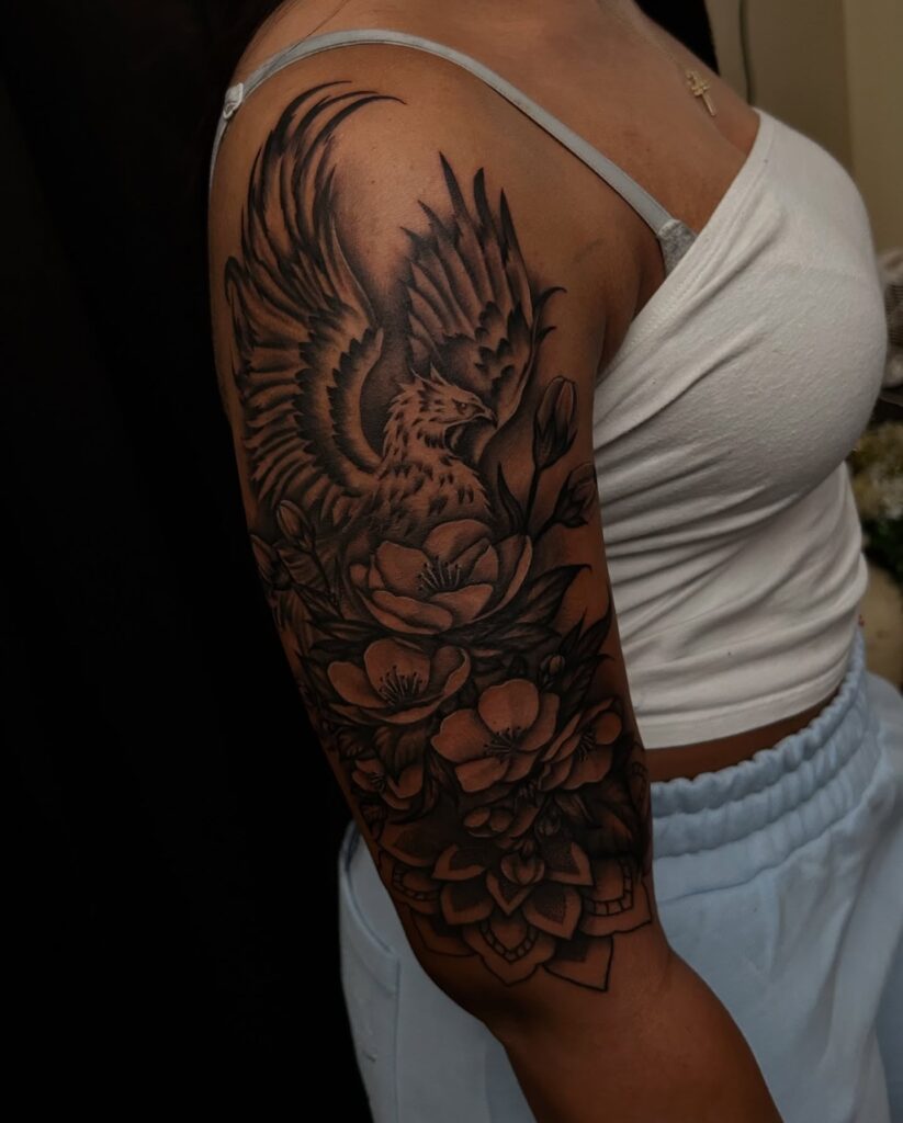 Black and grey phoenix tattoo sleeve with intricate shading and mandala design