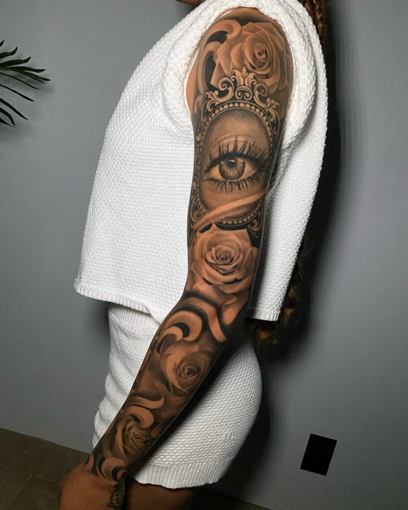 Black and grey realism tattoo sleeve with eye, roses, and baroque elements