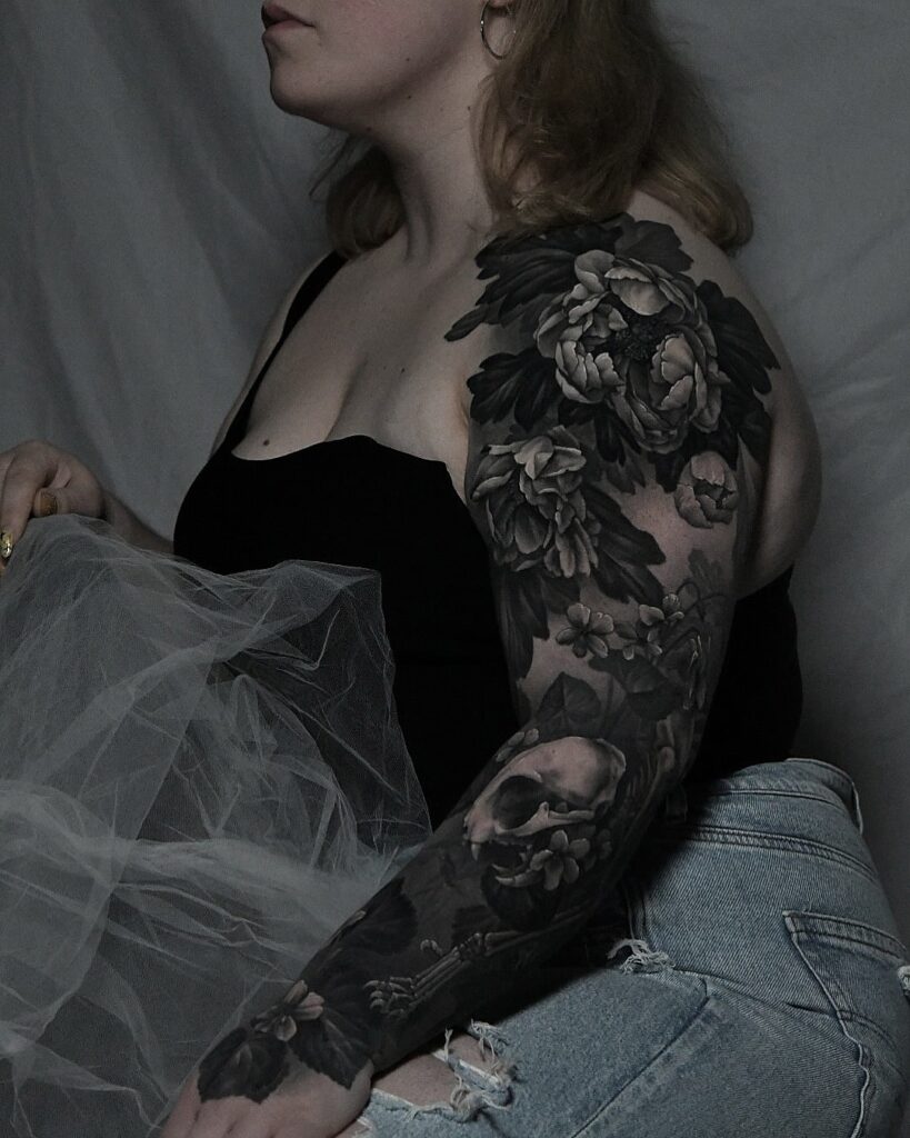Black and grey realism tattoo sleeve with peonies and skull contrast