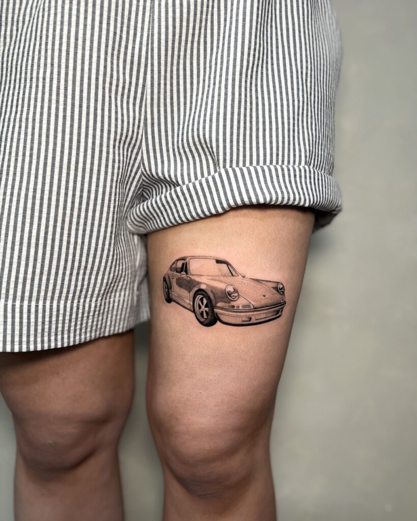 Black and Grey Realistic Porsche 911 Tattoo on Upper Thigh