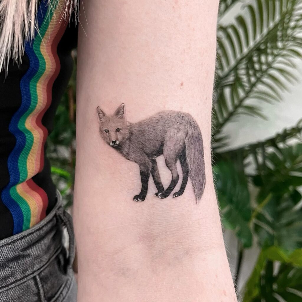 Black and Grey Side View Fox Tattoo on the Above Elbow, Gazing Coolly: Sleek Silhouette