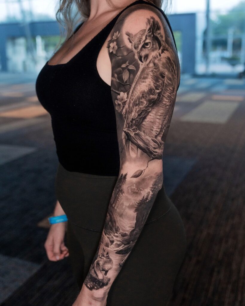 Black and grey wildlife realism tattoo sleeve featuring owl and forest landscape
