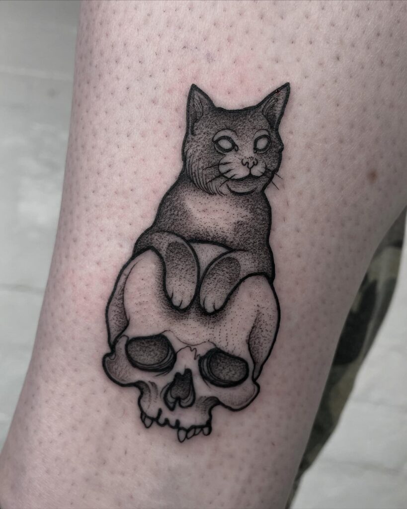 Black cat sitting on skull tattoo gothic dotwork design meaning