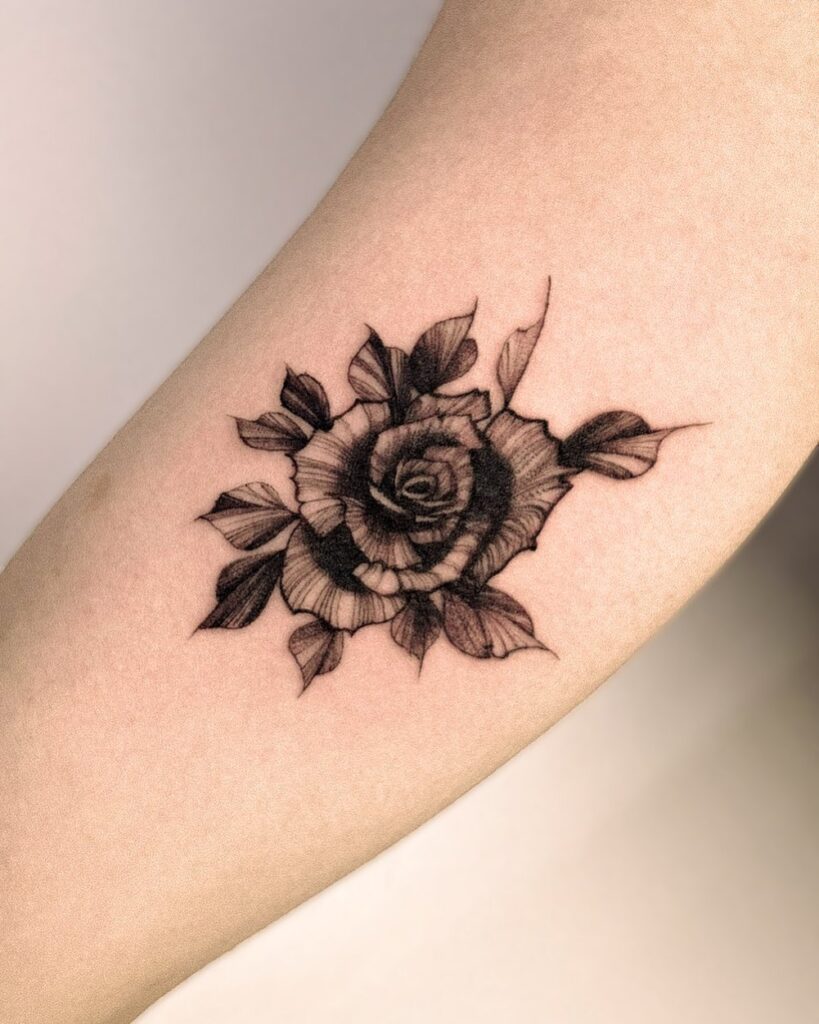Black rose flower tattoo on the bicep timeless grace for women