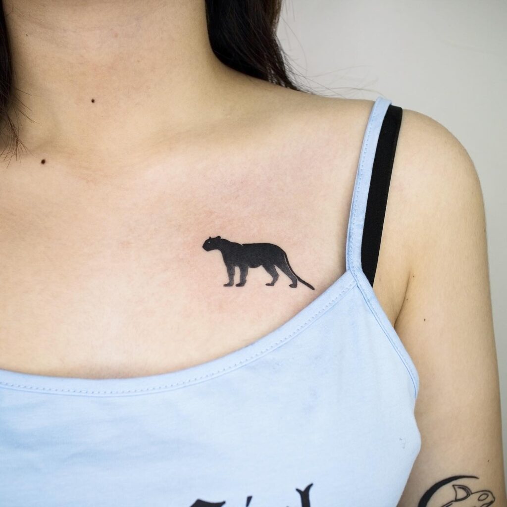 Black silhouette of panther tattoo on the collarbone, a bold and striking design panther silhouette
