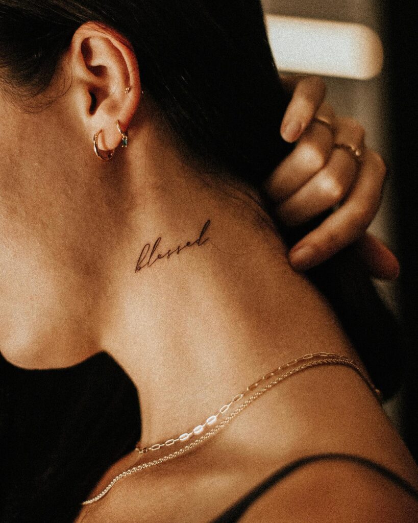 Blessed beauty word tattoo gracing the side of a girls neck