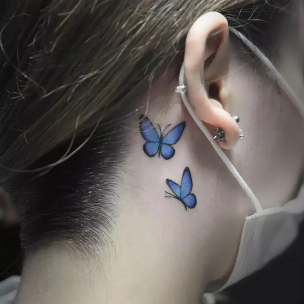 Blue butterfly tattoo behind ear