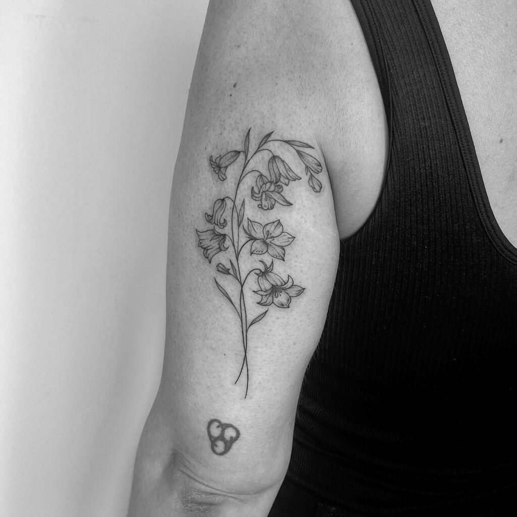 Bluebell tattoo behind the outer above the elbow creative placement