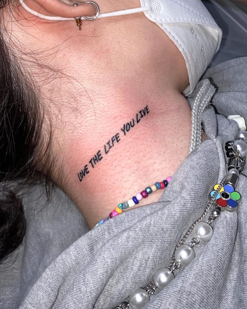 Bold caps "Love The Life You Live" on right neck vividly bold embrace life