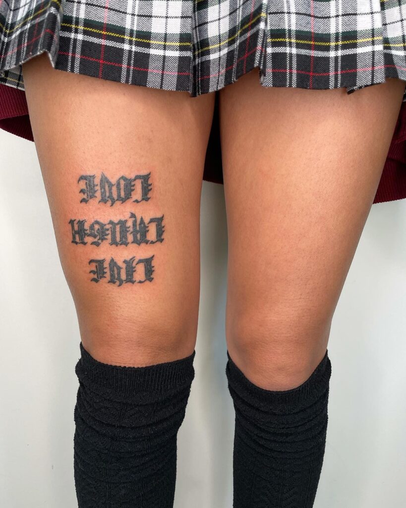 Bold 'Live Love Laugh' Text Tattoo Above the Knee for a Unique Touch: Knee Cap Serenity
