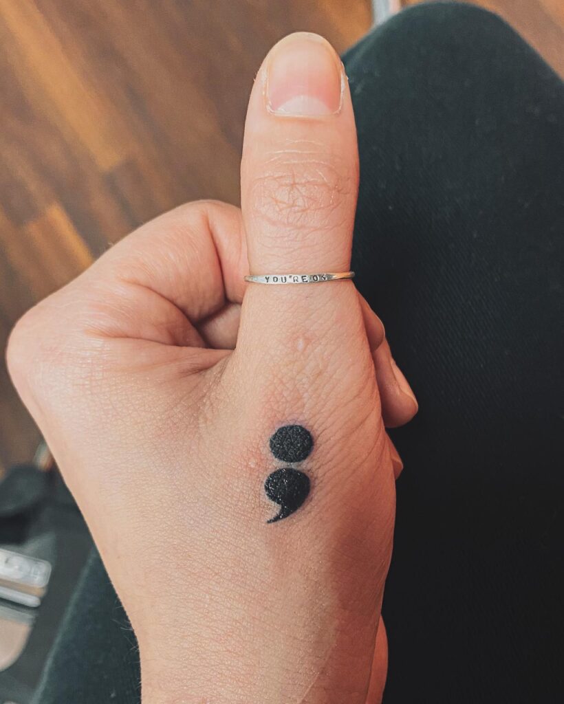 Bold Semicolon Tattoo on the Thumb Finger: Thumb Statement