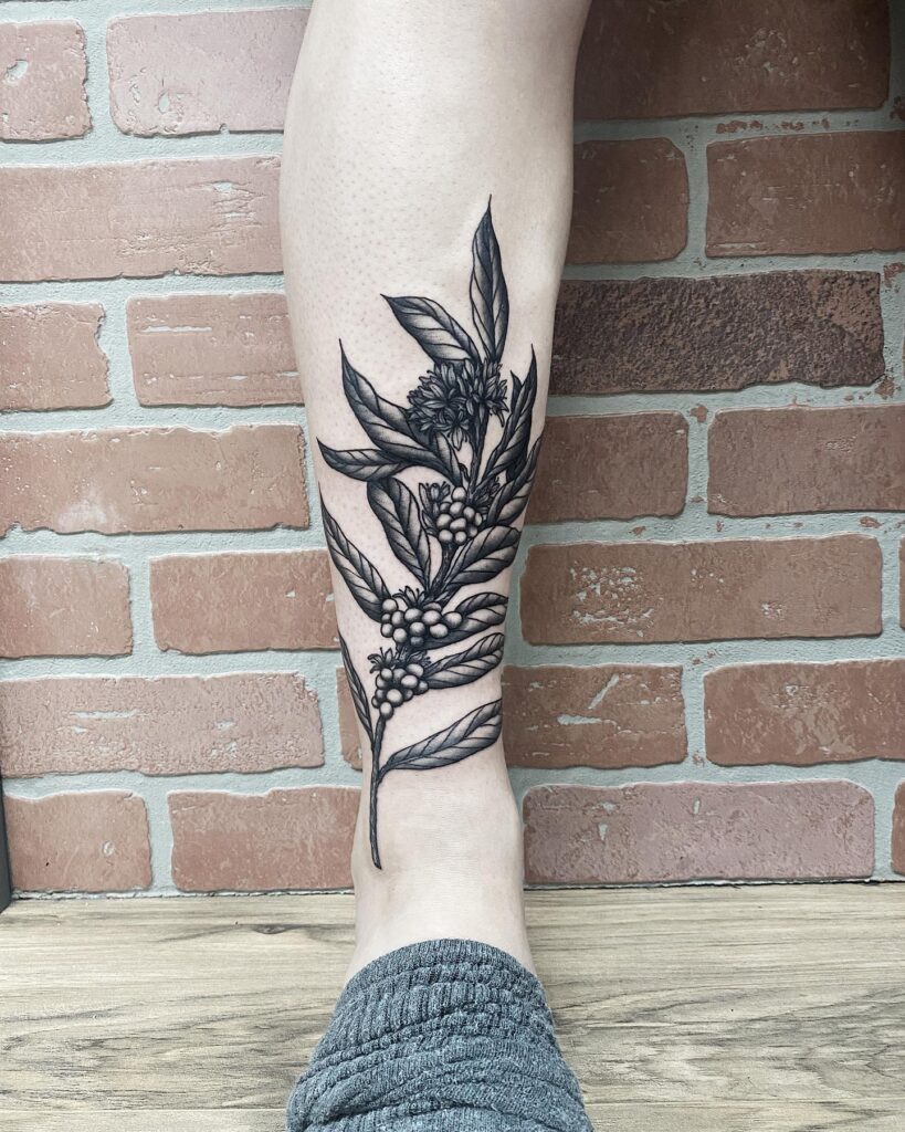 Caffeine chic black and grey coffee plant tattoo on lower leg