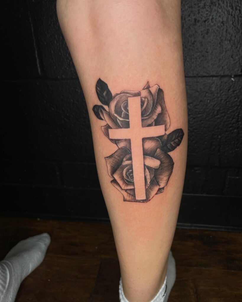 Calf tattoo cross with roses on the lower leg - a graceful and unique design