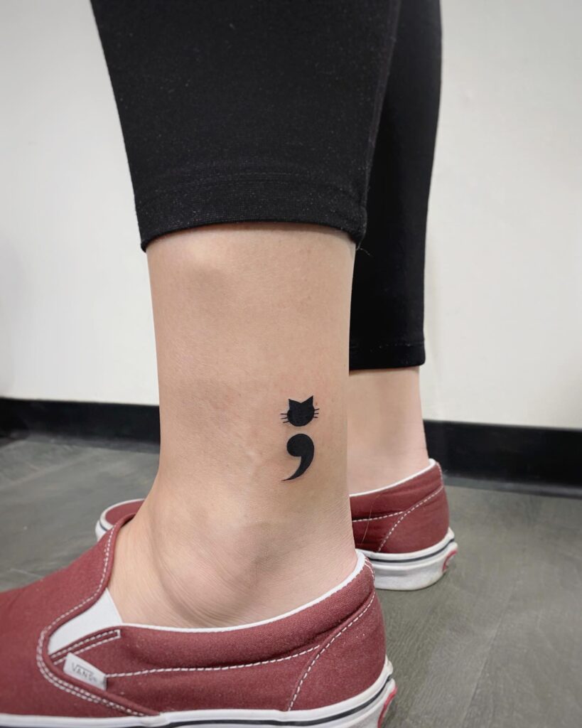 Cat Semicolon Tattoo Above the Ankle: Bold Feline Elegance