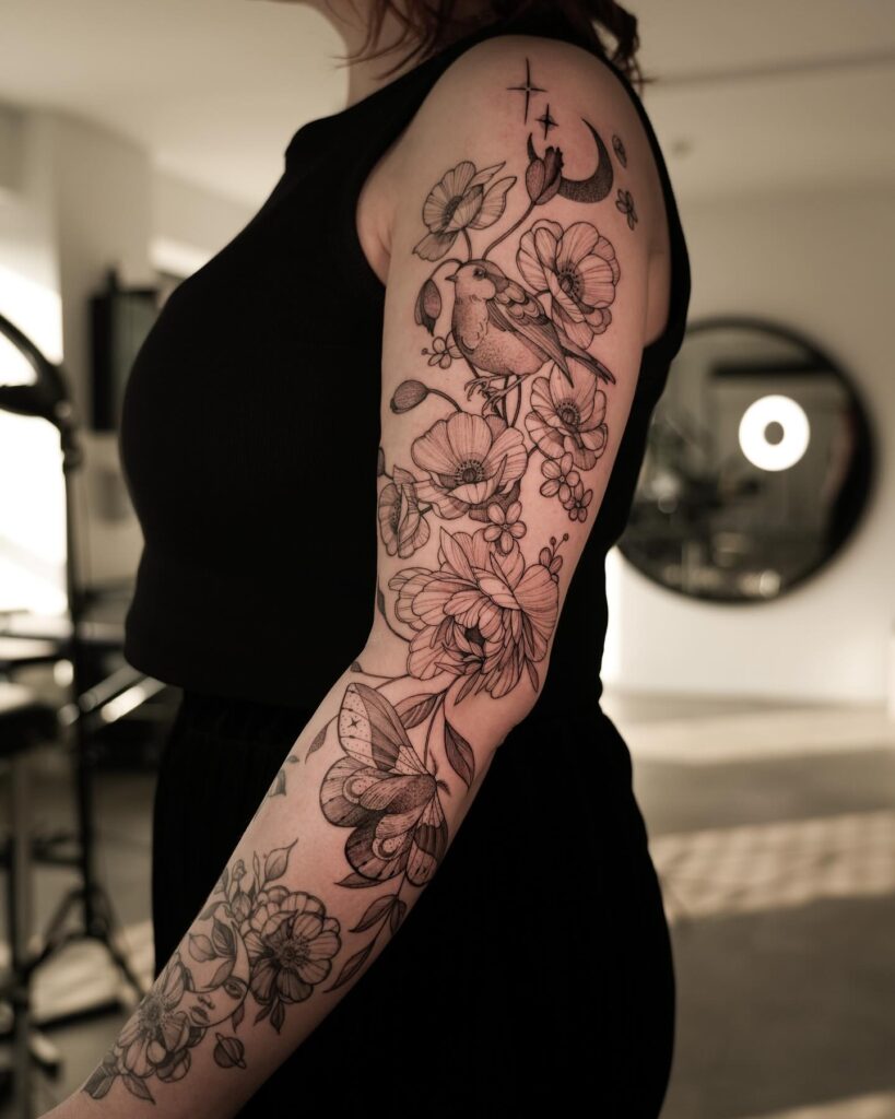 Celestial and floral tattoo sleeve featuring a crescent moon, stars, and butterflies