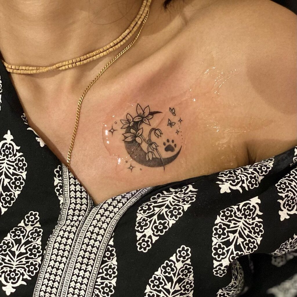 Celestial canine tribute moon flower and dog paw collarbone tattoo